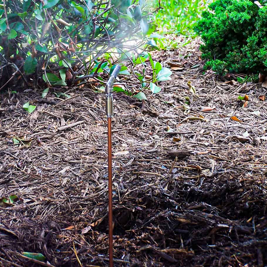 Sprinkler watering mulch in a garden